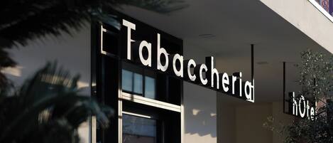 Entrada de un hotel con un letrero que dice "Tabaccheria Hotel".