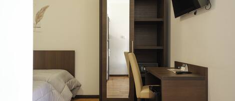 Una habitación pequeña con una cama, un escritorio y una silla.