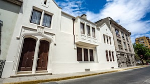Una hilera de edificios blancos con grandes puertas de madera y varias ventanas.