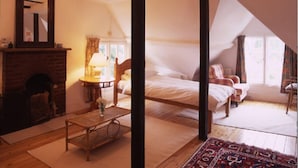 A bedroom with a four-poster bed, a fireplace, and a large window. - St Ethelwolds House (Abingdon)