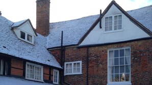 A traditional brick house with a snow-covered roof and a chimney. - St Ethelwolds House (Abingdon)