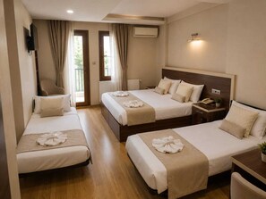 A hotel room with two beds, a desk, a chair, a TV, and a balcony. - Merkez Otel (Izmir)