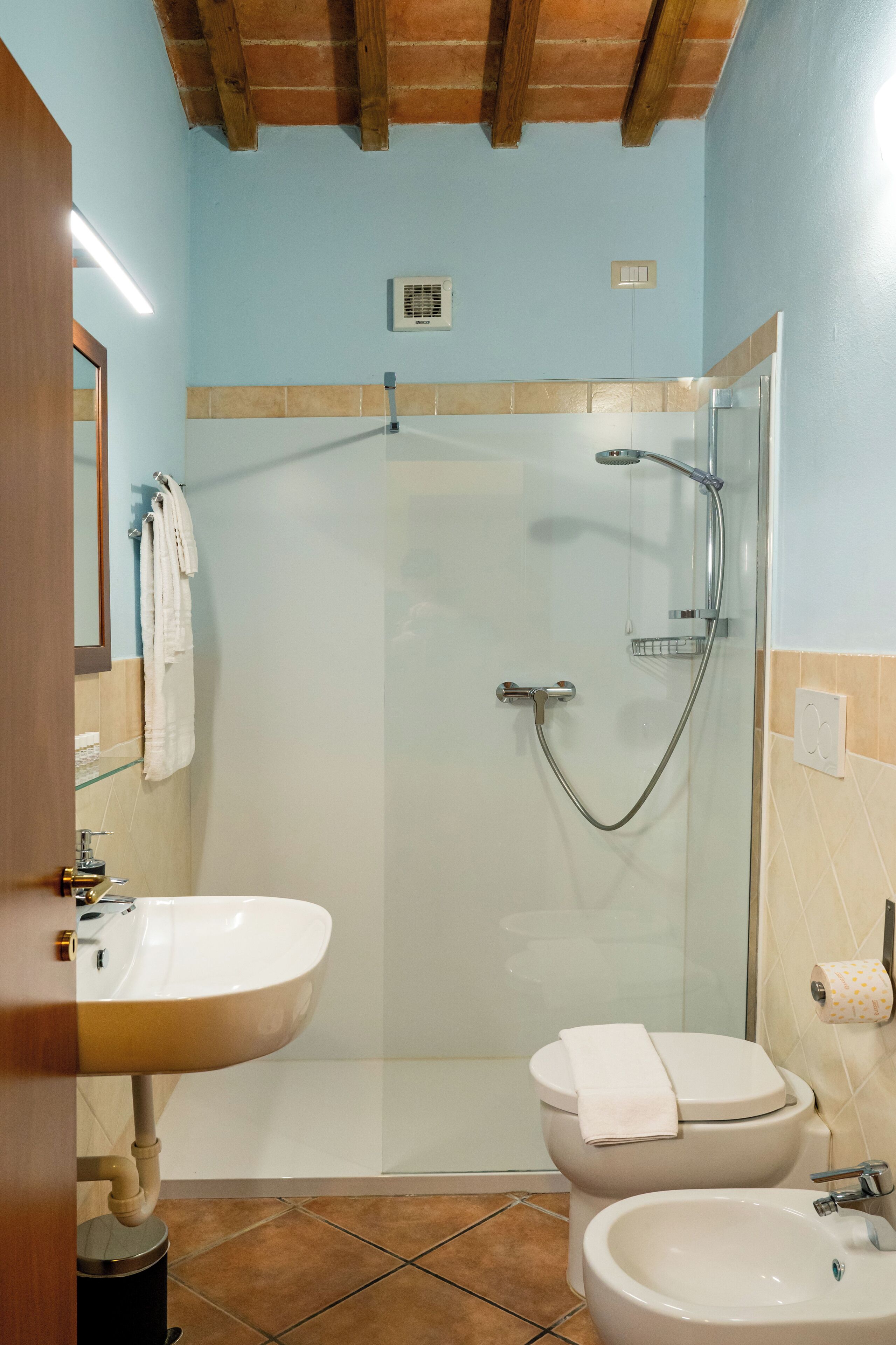 A bathroom with a shower, toilet, and sink.
