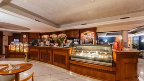 Un comptoir de boulangerie avec une vitrine, des meubles en bois et un espace où l’on peut s’asseoir, avec une table et des chaises.