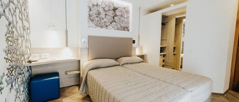 A modern bedroom with a bed, bedside table, and a wall-mounted artwork.