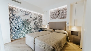 Une chambre moderne avec un lit, un mur orné de motifs évoquant des coraux et un mur à la texture pierre.