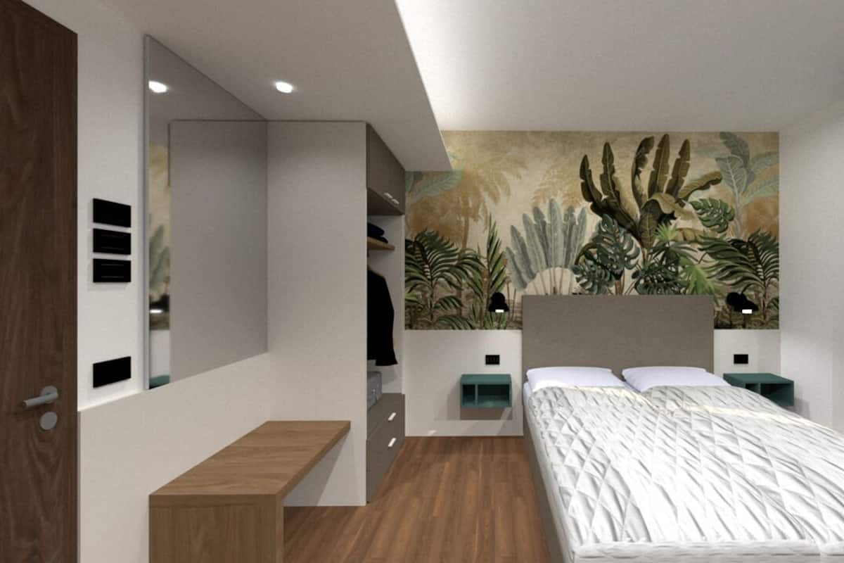 A modern bedroom with a bed, nightstands, a mirror, and a wall mural.