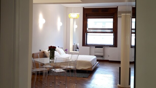 Une chambre moderne avec un lit, une table de chevet et une fenêtre.