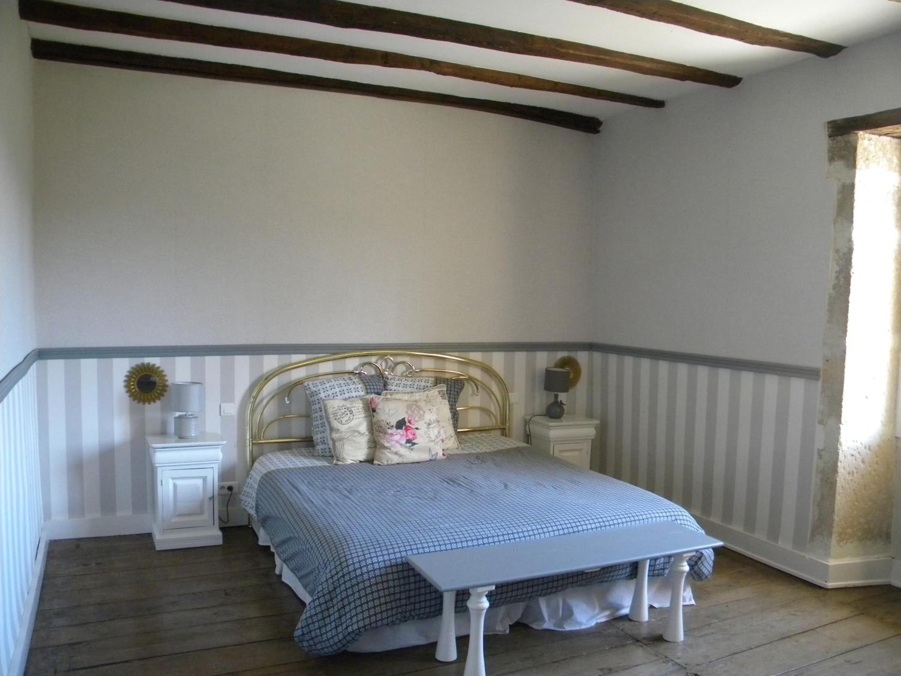 Un dormitorio con cama, mesitas de noche y un velador.