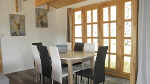 Un coin repas avec une table ronde, quatre chaises et un panier bleu.