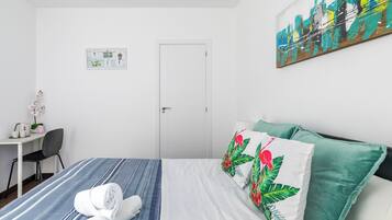 Una habitación de hotel con cama, escritorio, silla y puerta.