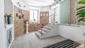 Ein modernes Interieur mit einer Ziegelwand, einer Treppe und einem großen Fenster.