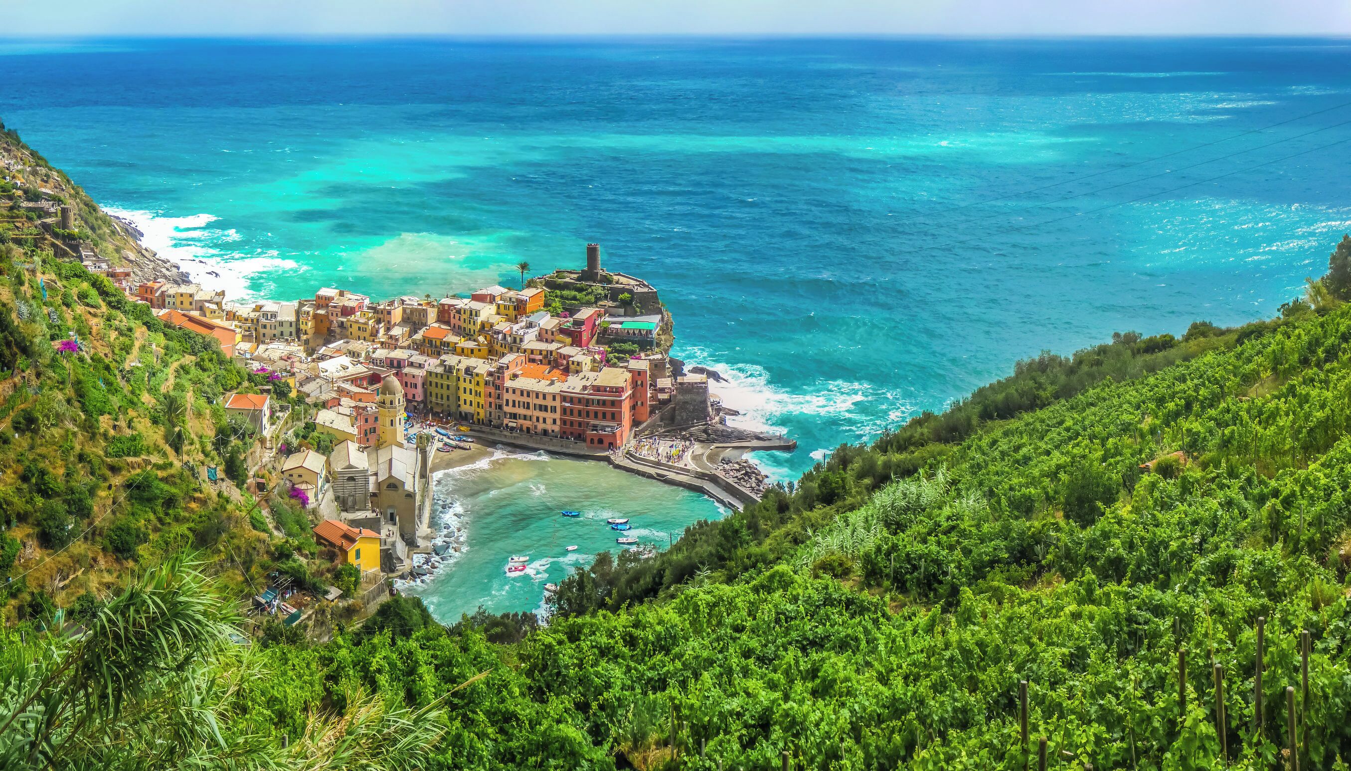 A coastal town with colorful buildings, a beach, and a view of the sea.