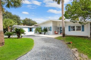 A single-story house with a gravel driveway and a lawn. - Heated Pool, Mini Golf, Walk to Beach, Beach Gear (St Augustine)