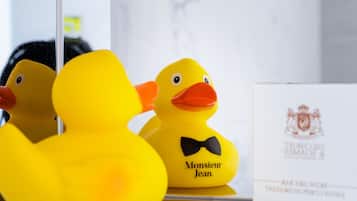 Two yellow rubber ducks with black bow ties and a white envelope with a crest.