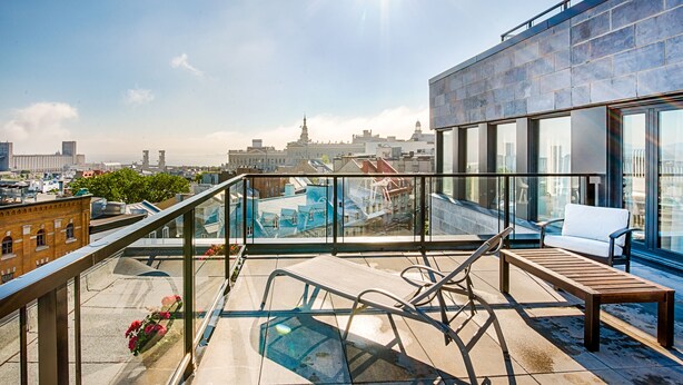 A rooftop terrace with a pool, lounge chairs, and a view of the city skyline. - Monsieur Jean, Vieux Québec (Québec City)