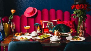 A dining table set with various dishes, a red upholstered bench, and a decorative fan. - Monsieur Jean, Vieux Québec (Québec City)