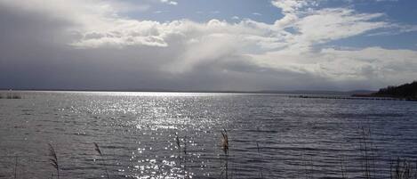 Un lac paisible, avec un ciel dégagé et une rive lointaine.