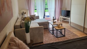 Een moderne woonkamer met een bank, een salontafel en een televisie op een dressoir.