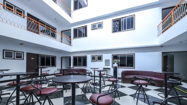 A multi-level atrium with a checkered floor, seating areas, and a balcony with orange railings. - OYO 89571 Eco Palace Hotel (Kuala Lumpur)