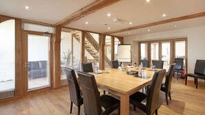 A conference room with a wooden table, black chairs, and a whiteboard. - Cold Cotes Guest House (Harrogate)