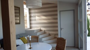 Een modern interieur met een trap, een ronde tafel en een stoel.