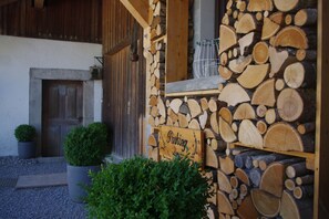 Un bâtiment rustique avec un mur en pierre et une enseigne en bois sur laquelle on peut lire « Parking ».