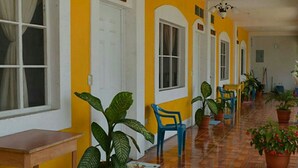 Un pasillo con paredes amarillas, puertas blancas y suelo de madera.
