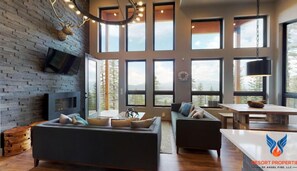 Relax in this inviting living space with a large sofa, armchair, and fireplace.