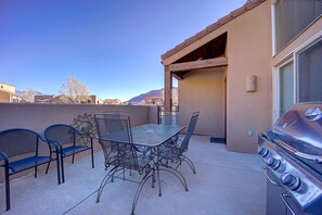 An outdoor patio with a metal table and chairs, a barbecue grill, and a view of mountains. - Awesome Retreat Pool ,Hot tub, 2 car garage (Moab)