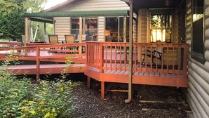 A cabin with a porch, outdoor seating, and a covered area. - Lake Michigan Beach Home with Over 100’ of Private Sand Beach! Pets Welcome!  (Sturgeon Bay)