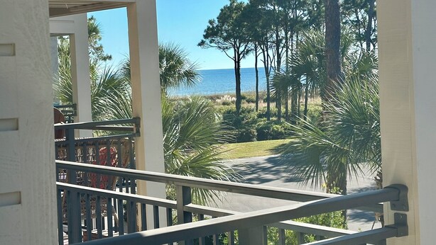 A balcony with a view of the ocean and palm trees. - Sandy Feet Retreat-New Shower-Bikes Incl-Oceanview (Hilton Head Island)