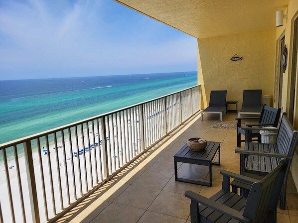 A balcony with a view of the ocean, featuring a railing, a table with a bowl, and two chairs. - Gorgeous 2 Bedroom, King Beds; Spectacular Gulf Views; Newly renoated (Panama City Beach)
