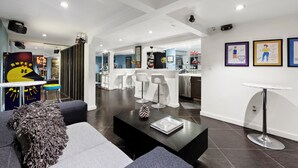 Un intérieur moderne avec un bar, des sièges et des œuvres d’art accrochées aux murs.