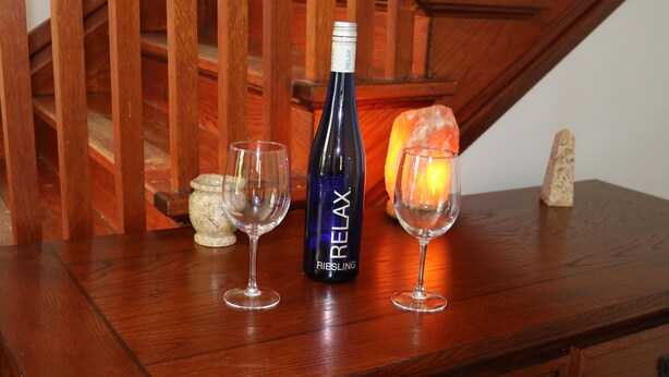 A wooden table with a bottle of wine, two glasses, and a candle. - Whole House, 5 minutes by car to OU, 2 Bedroom, 1.5 bath, Smart TV, FREE Wi-Fi (Athens)