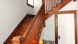 A wooden staircase with a handrail, a door with a lock, and a window with a wooden frame. - Whole House, 5 minutes by car to OU, 2 Bedroom, 1.5 bath, Smart TV, FREE Wi-Fi (Athens)