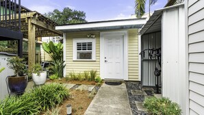A residential property with a front door, a small porch, and a garden with various plants.