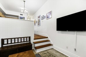 A staircase with wooden steps and a dark bench at the bottom.