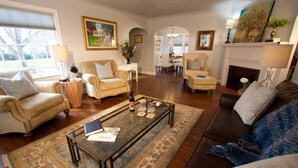 A spacious living room with a coffee table, sofas, and a fireplace. - Boyer Place · Boyer Place, Updated Home - Walk to Campus & Town (Walla Walla)