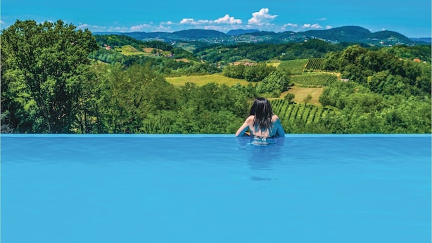 A person in a swimming pool with a view of green hills and vineyards. - Awesome Home in Lepajci w/ Sauna, Wifi and 3 Bedrooms (Krapina)
