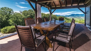 An outdoor wooden table and chairs with a view of a green landscape and mountains. - Awesome Home in Lepajci w/ Sauna, Wifi and 3 Bedrooms (Krapina)