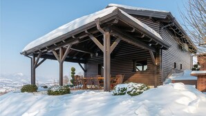 A wooden cabin with a covered patio, surrounded by snow. - Awesome Home in Lepajci w/ Sauna, Wifi and 3 Bedrooms (Krapina)