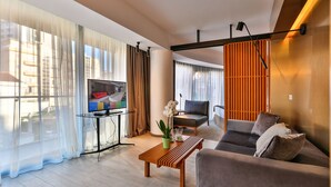 Un salon moderne avec un canapé, une table basse, un téléviseur et une plante en pot.