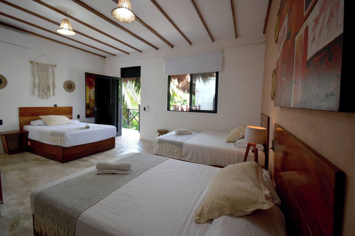 Una habitación de hotel con dos camas, un ventanal grande y un cuadro en la pared.