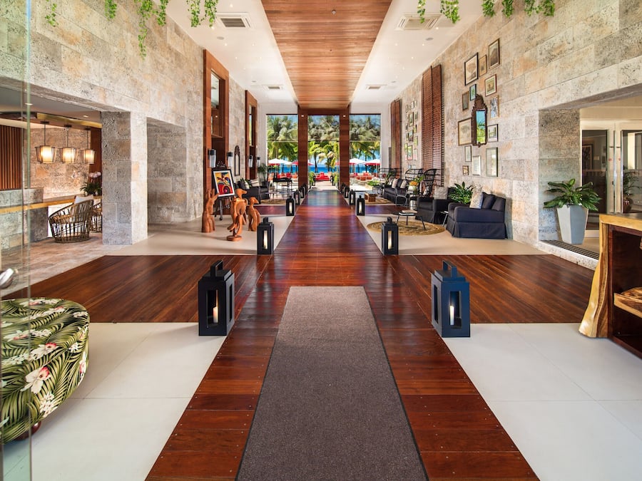 Eine großzügige Lobby mit Holzboden, Sitzbereichen und einer Rezeption.