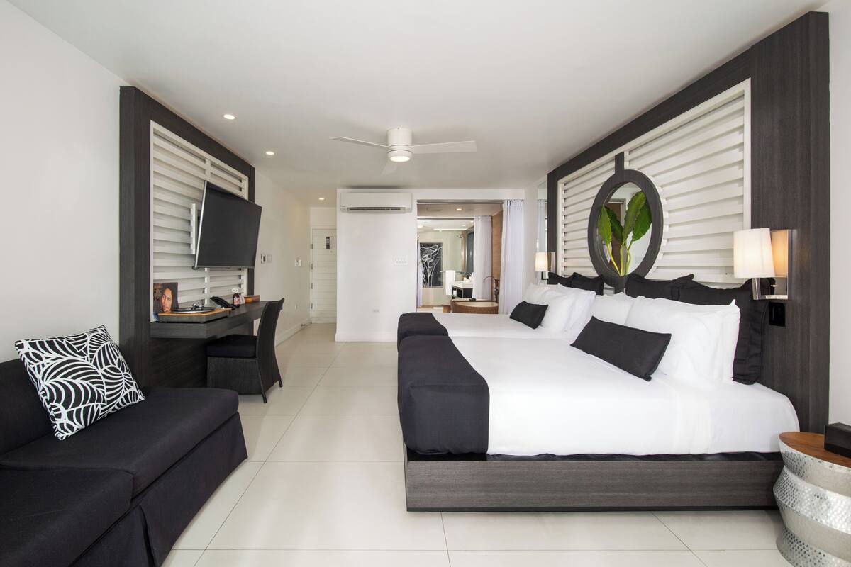 Una habitación de hotel moderna con una cama grande, un sofá, un escritorio y una televisión.