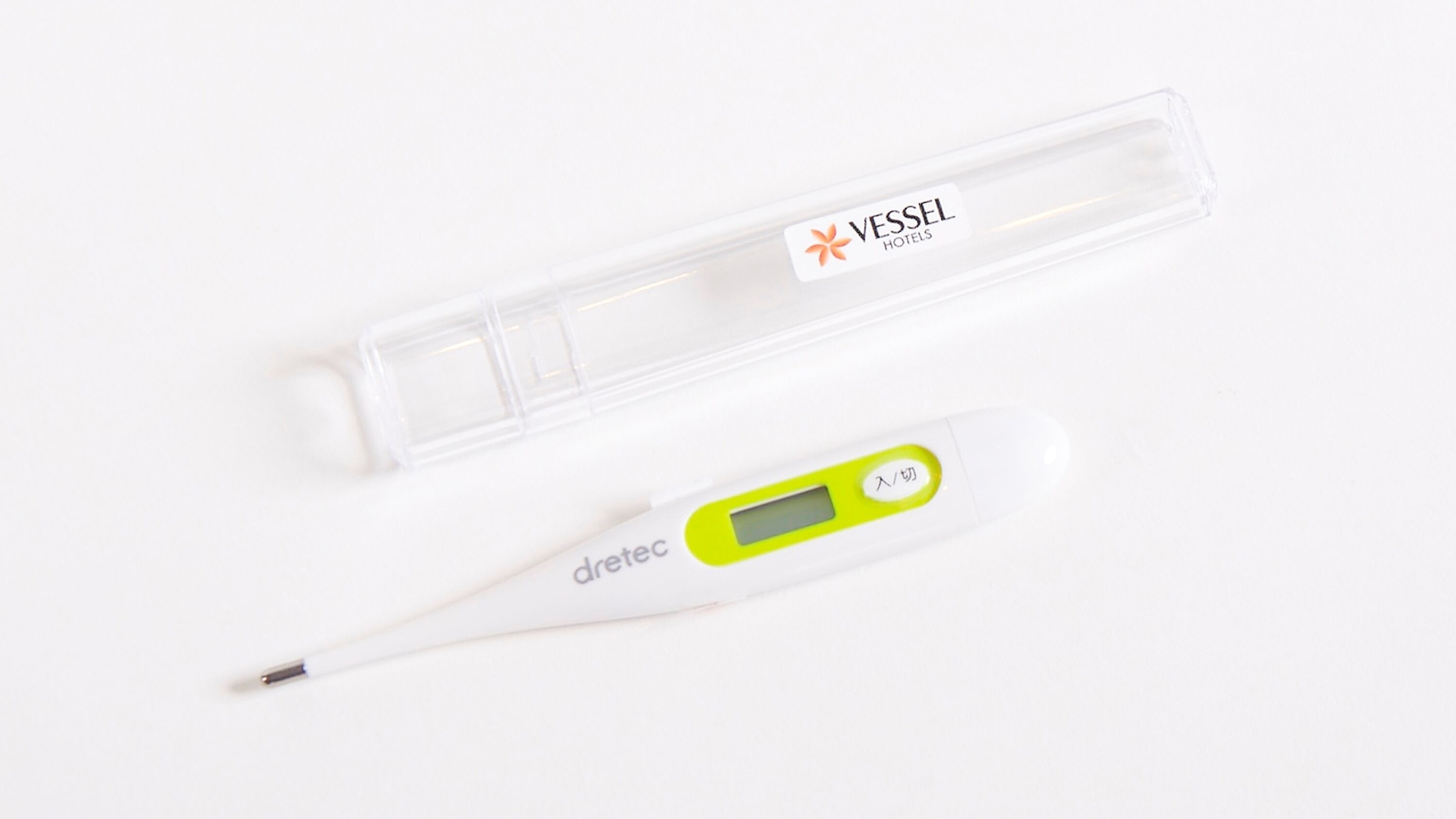 A digital thermometer and a clear plastic case with a label.