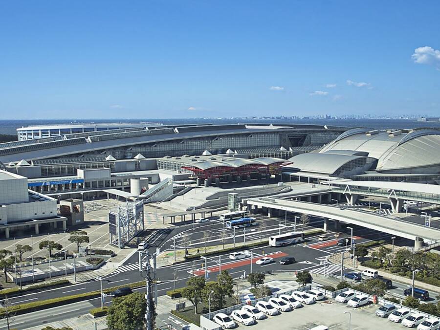 Un terminal d’aéroport comportant plusieurs niveaux, un parking et un pont reliant les différentes sections.