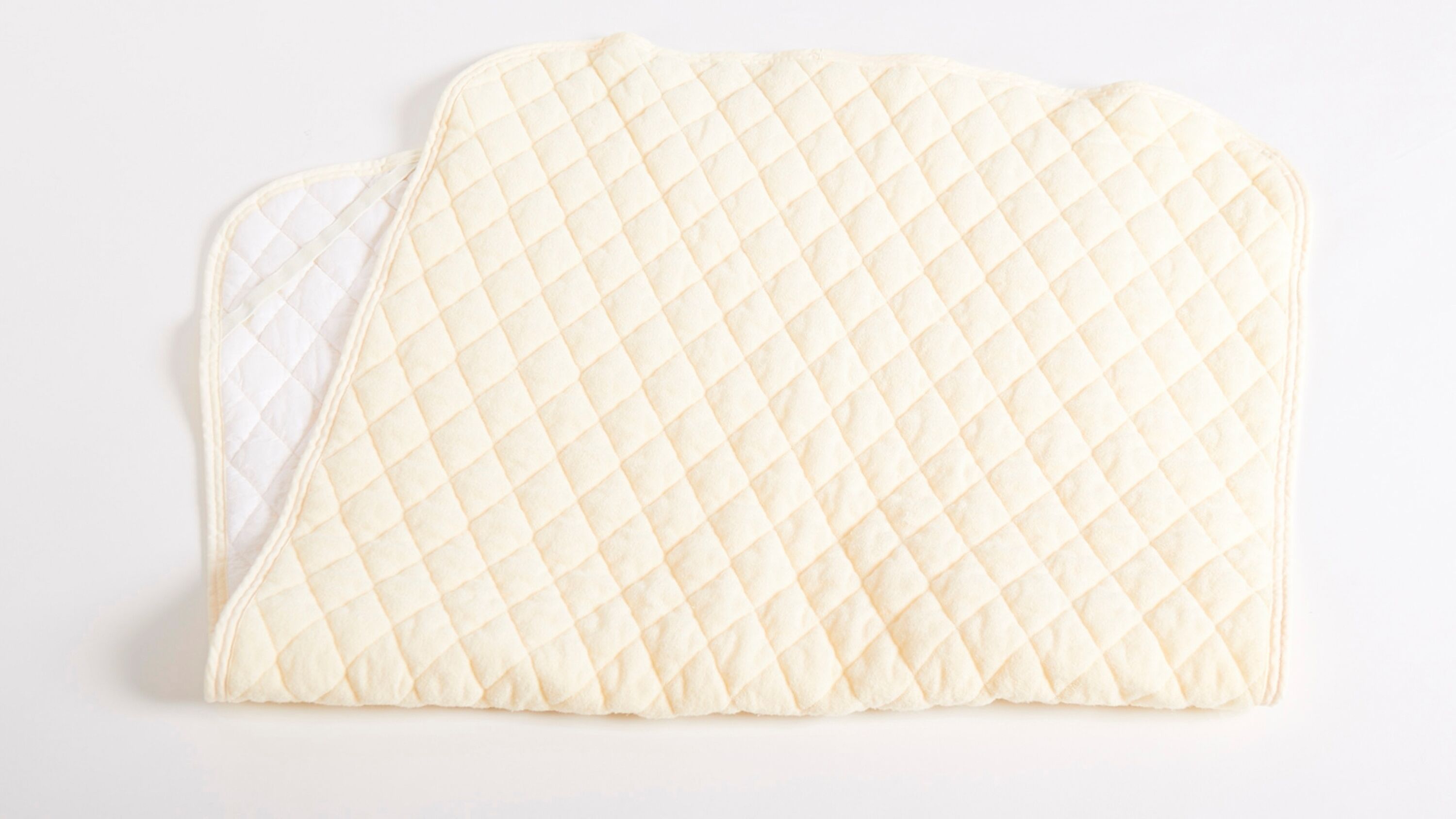 A quilted, padded item with a diamond pattern, likely a cushion or pillow.