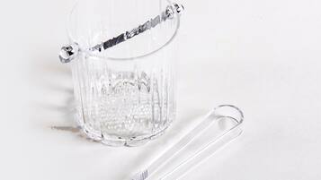 A clear glass mug with a handle and a clear plastic spoon beside it.